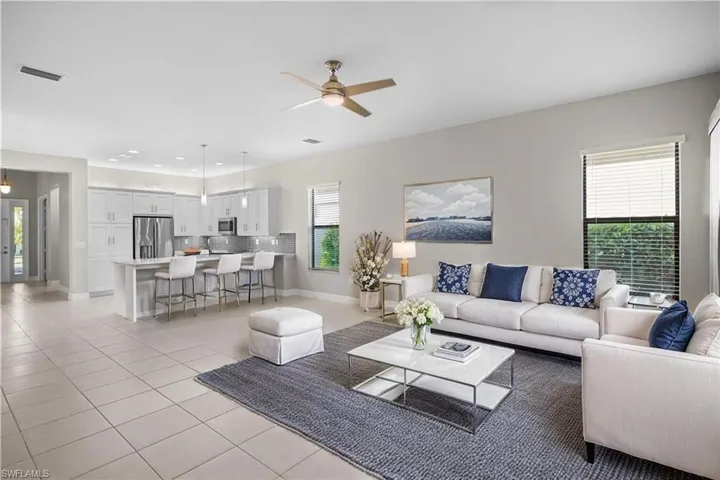 Living area with light tile patterned floors and a ceiling fan