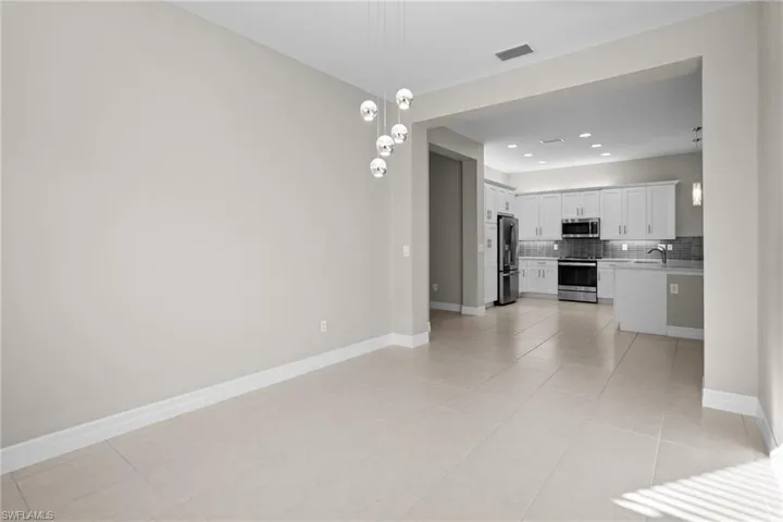Unfurnished living room featuring a chandelier, light tile patterned floors, and recessed lighting