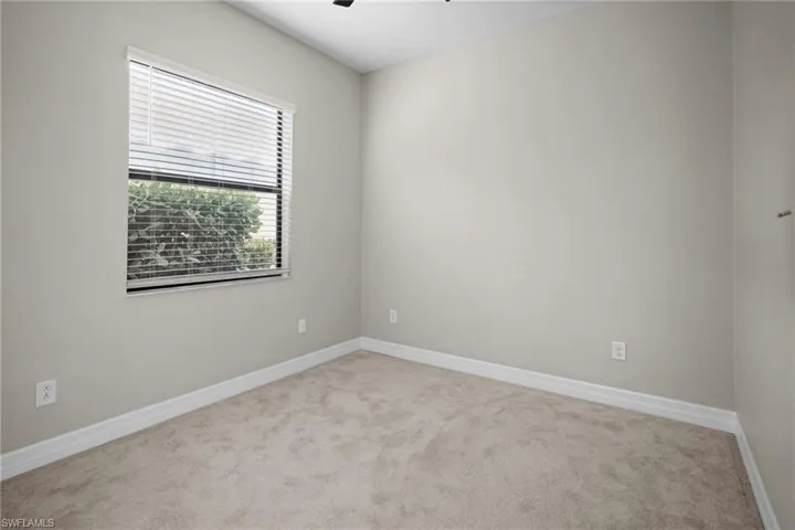 Carpeted spare room featuring baseboards and ceiling fan