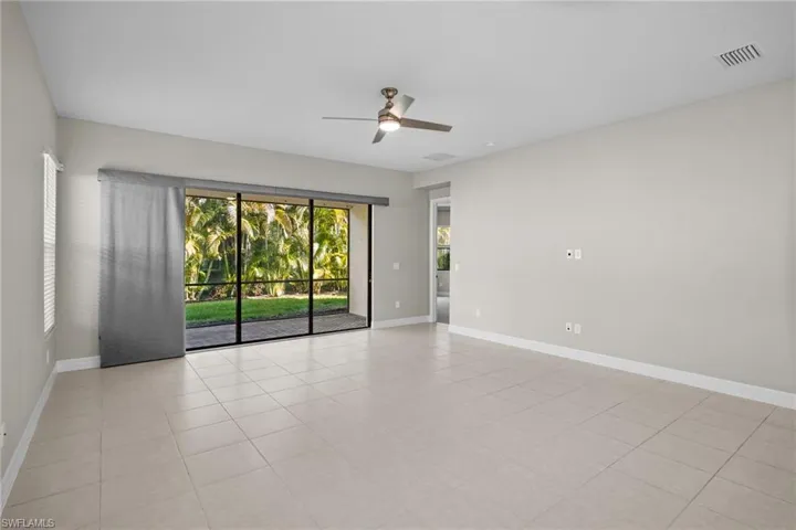 Empty room featuring light tile patterned flooring and ceiling fan