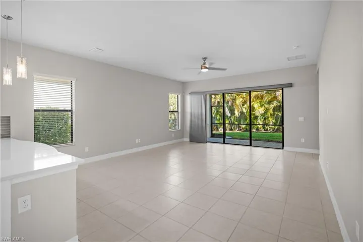 Unfurnished room with light tile patterned floors, healthy amount of natural light, and a ceiling fan