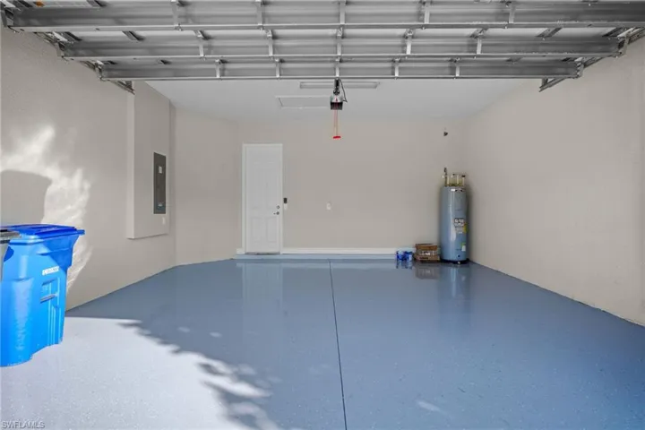 Garage featuring electric water heater and electric panel
