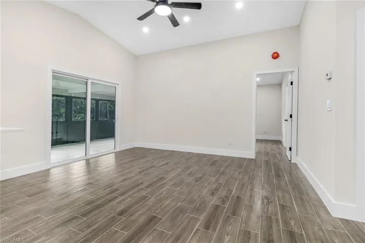 Spare room with wood tiled floors, recessed lighting, high vaulted ceiling, and ceiling fan