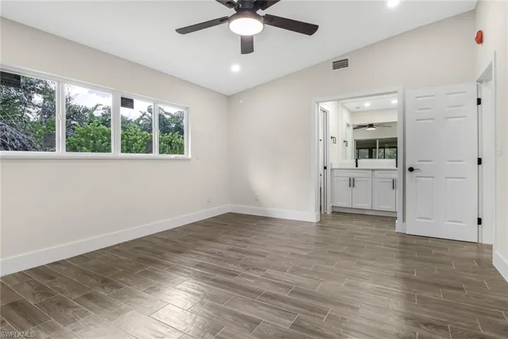 Empty room featuring a ceiling fan, wood finish floors, plenty of natural light, and recessed lighting