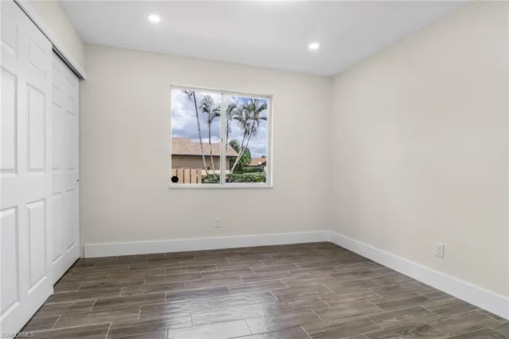 Unfurnished bedroom featuring wood finish floors, a closet, and recessed lighting