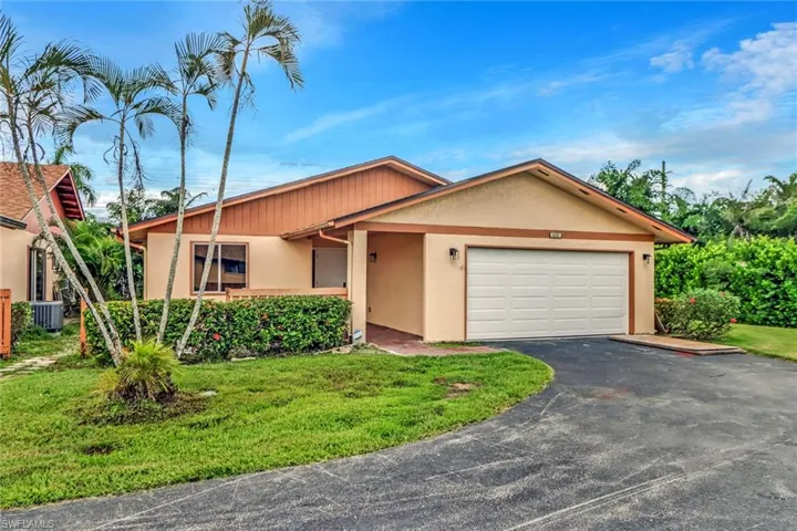 Ranch-style home featuring stucco siding, driveway, a front yard, and an attached garage
