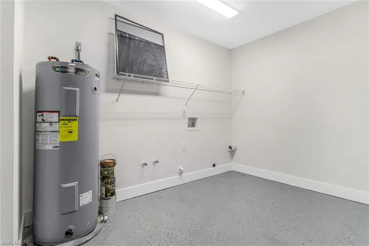 Laundry in Garage featuring gas dryer hookup, electric water heater, washer hookup, and hookup for an electric dryer