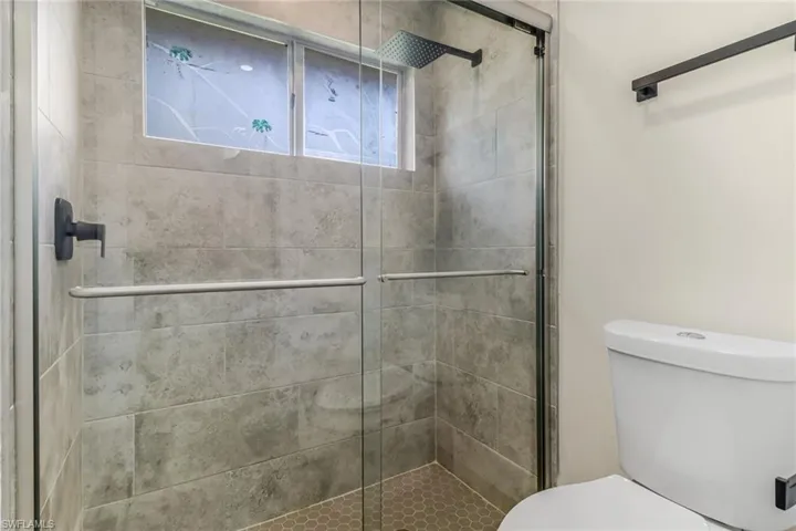 Bathroom featuring a shower stall and toilet