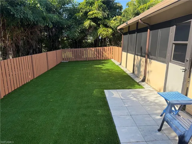 Fenced backyard with a sunroom