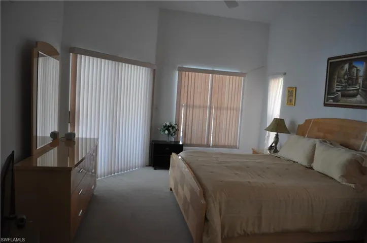 Bedroom featuring carpet floors, ceiling fan, and a towering ceiling