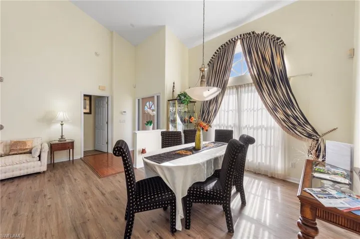 Dining room with a towering ceiling and light wood-style flooring