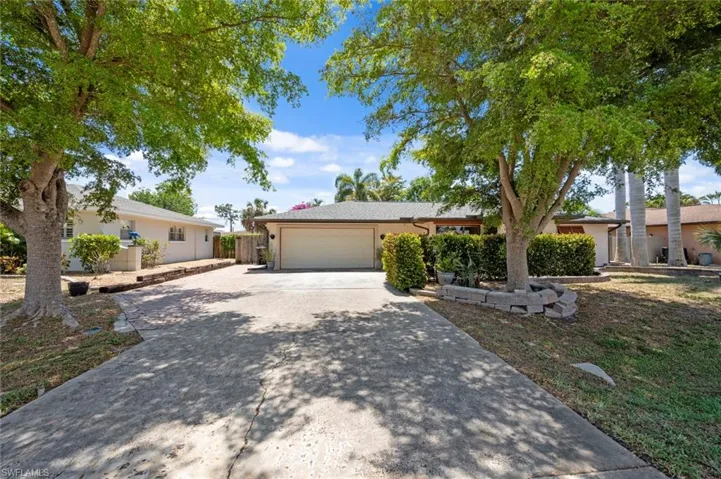 Ranch-style home featuring stucco siding, a garage, and concrete driveway