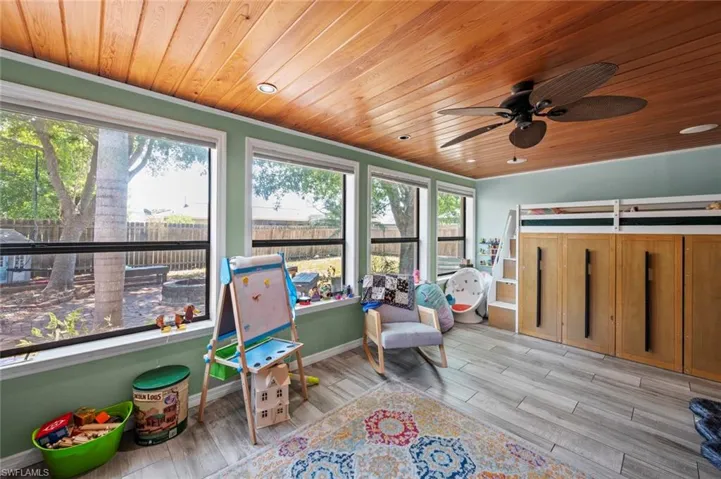 Sunroom / solarium with baseboards, wooden ceiling, and wood finished floors
