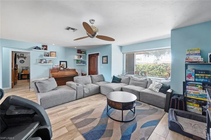 Living room with visible vents, a ceiling fan, and wood finished floors