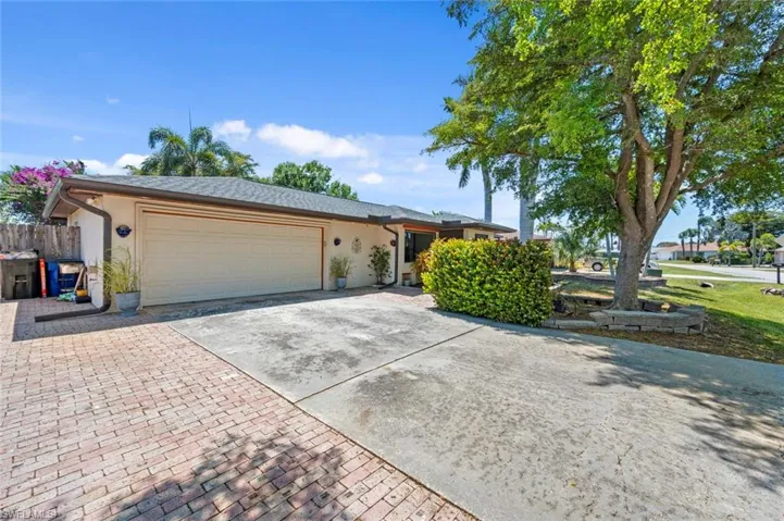 Single story home with a garage, driveway, fence, and stucco siding