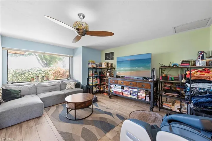 Living room featuring ceiling fan, attic access, and wood finished floors