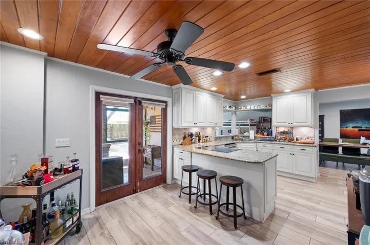 Kitchen with white cabinets, wooden ceiling, and visible vents