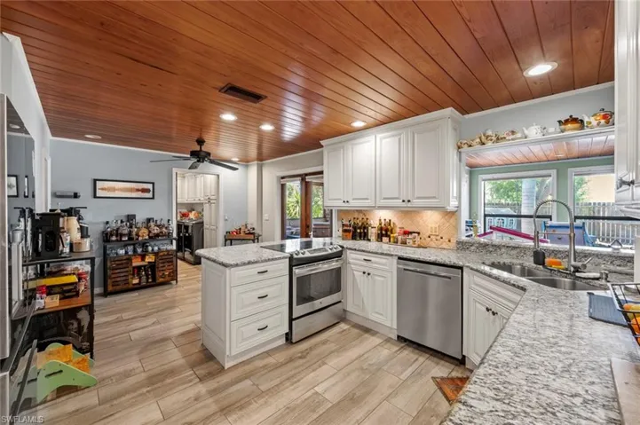 Kitchen featuring stainless steel appliances, wooden ceiling, visible vents, and a sink