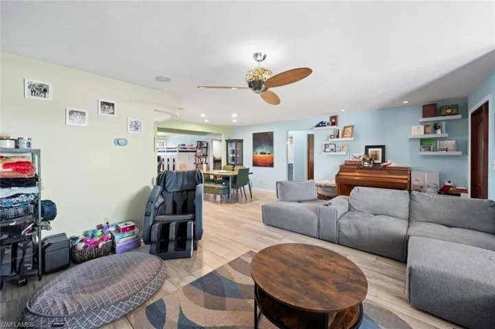 Living area featuring a ceiling fan, recessed lighting, and light wood finished floors