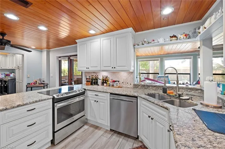 Kitchen with wooden ceiling, a sink, visible vents, and stainless steel appliances
