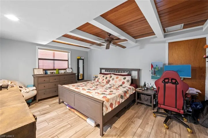 Bedroom featuring wood ceiling, a ceiling fan, beam ceiling, and wood finished floors