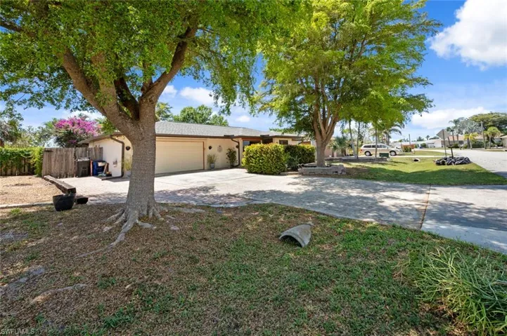 Ranch-style home featuring a front yard, an attached garage, fence, stucco siding, and driveway