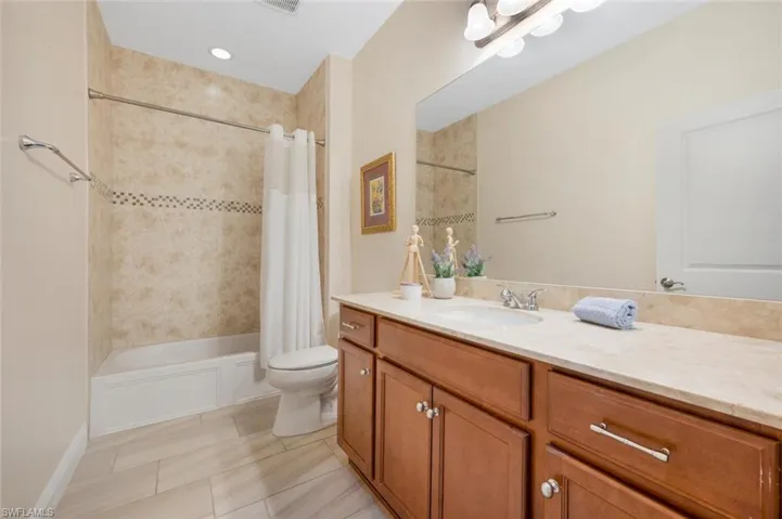 Second bathroom featuring shower / bath combination with curtain, vanity, toilet, and tile floors