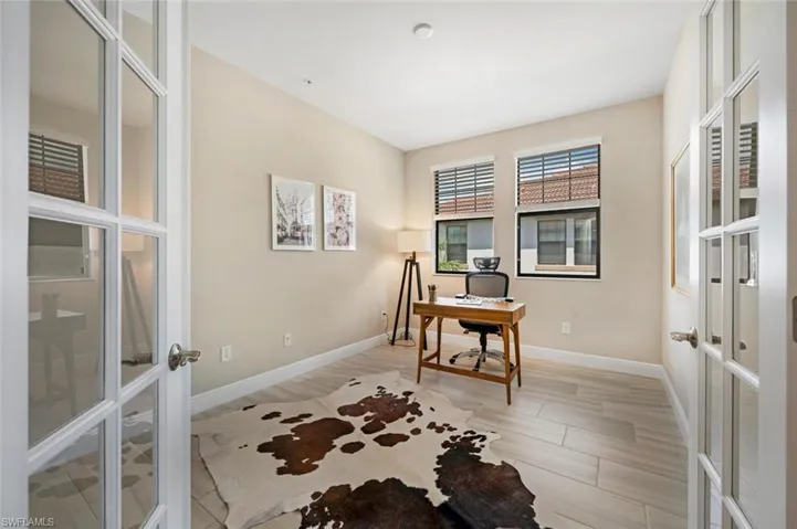 Home office with light tile flooring and French doors