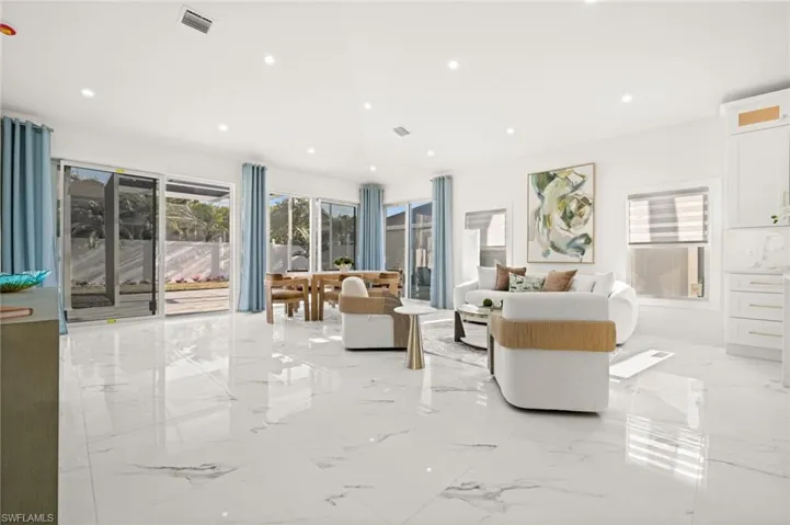 Living area featuring plenty of natural light, recessed lighting, and light marble finish floors