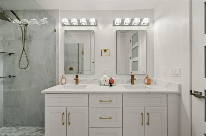 Bathroom featuring double vanity and a stall shower