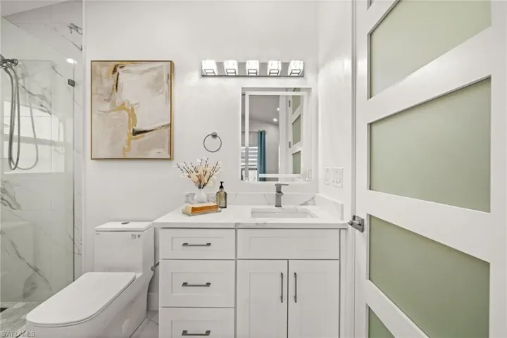 Full bathroom featuring vanity and a marble finish shower