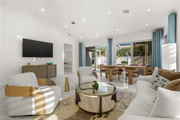 Living room featuring lofted ceiling and recessed lighting
