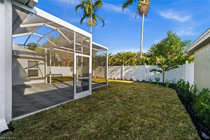 Fenced backyard featuring a lanai and a sunroom
