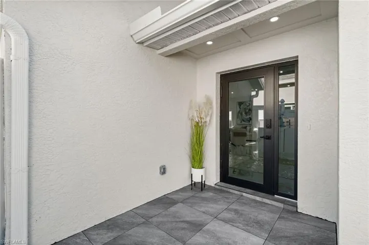 Doorway to property with stucco siding and french doors