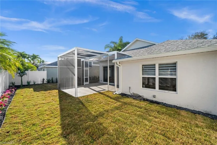 Rear view of property featuring a sunroom, a lanai, stucco siding, a patio area, and a fenced backyard