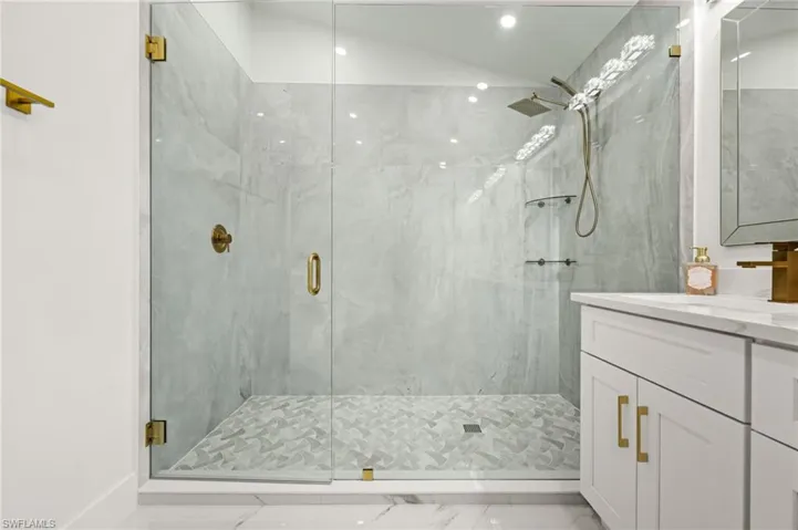 Full bathroom with vanity and a marble finish shower