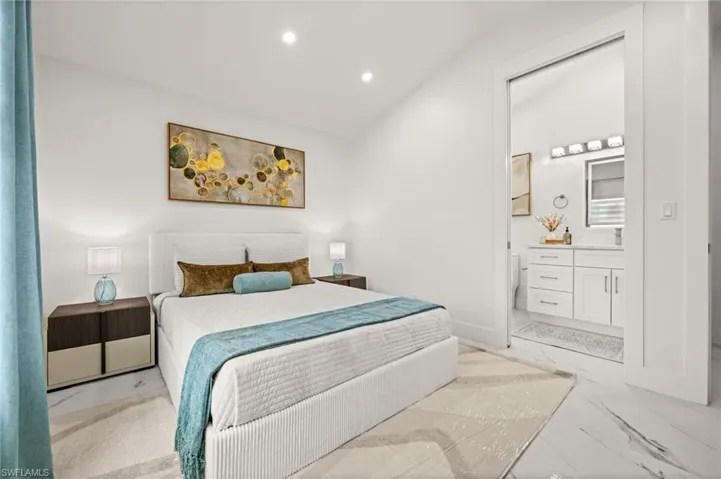 Bedroom featuring vaulted ceiling, recessed lighting, and light marble finish floors