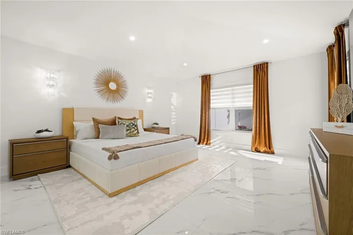 Bedroom with light marble finish floors and recessed lighting