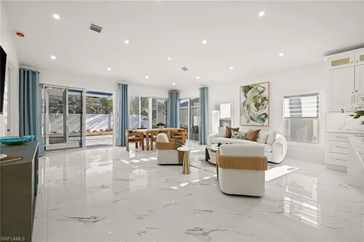 Living area with light marble finish floors and recessed lighting