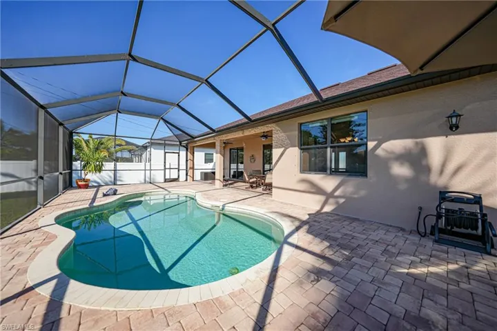 View of pool featuring ceiling fan, a lanai, and a patio