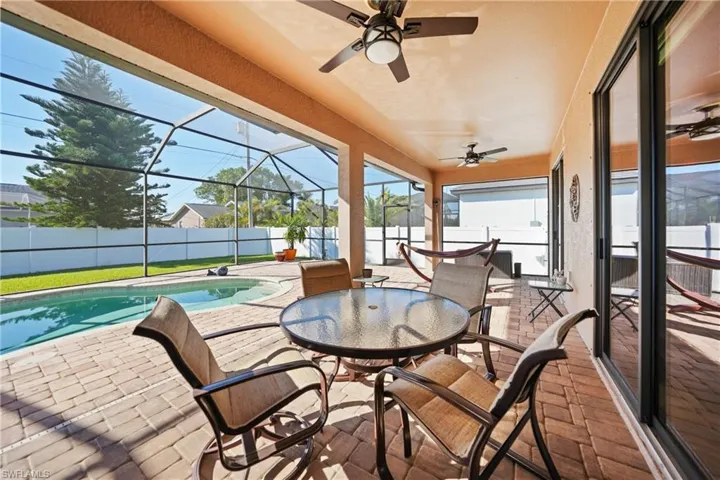 View of patio / terrace featuring a lanai, ceiling fan, and a fenced in pool