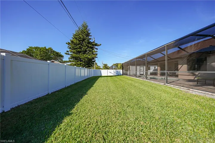 View of yard featuring glass enclosure, a patio area, and a pool