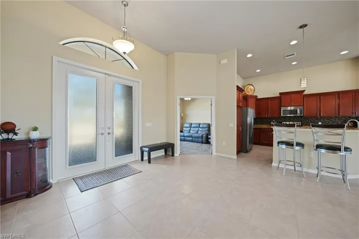 Kitchen with a kitchen breakfast bar, tasteful backsplash, decorative light fixtures, and appliances with stainless steel finishes