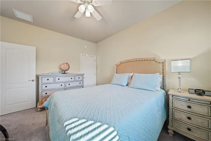 Carpeted bedroom featuring ceiling fan