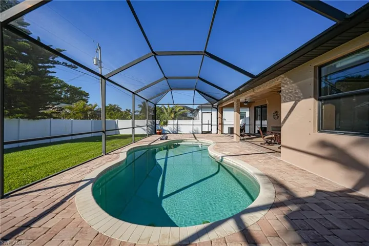 View of swimming pool with a lawn, a lanai, ceiling fan, and a patio area
