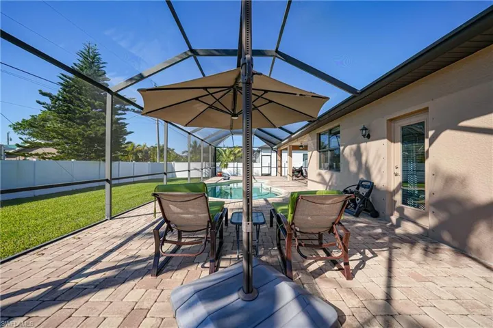 View of patio with glass enclosure and a fenced in pool