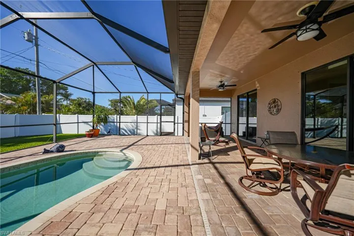 View of swimming pool with a lanai, ceiling fan, and a patio