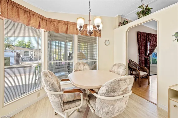 Dining area featuring baseboards, light wood-style floors, an inviting chandelier, and crown molding