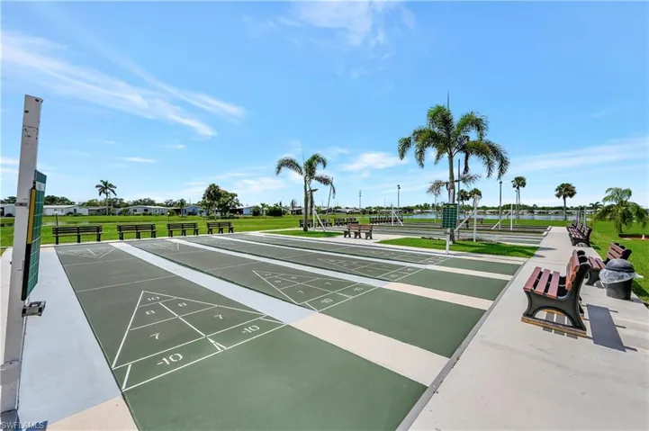View of property's community featuring shuffleboard and a lawn