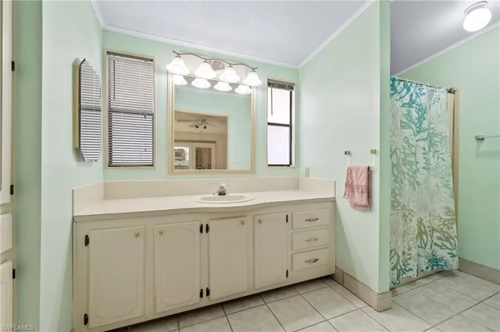 Full bathroom featuring vanity, crown molding, and tile patterned floors